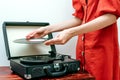 Young woman on retro dress playing vinyl record on turntable Royalty Free Stock Photo