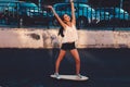 Young woman ride on skateboard in happy state celebrate summer freedome with her hands rised outdoors active lifestyle Royalty Free Stock Photo