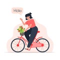 A young woman rides a bicycle with a bouquet of flowers in a basket Royalty Free Stock Photo