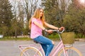 A young woman rides on a bicycle on the road in the park Royalty Free Stock Photo