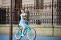 Young woman rides on retro bike holding her peonies Royalty Free Stock Photo