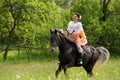 Young woman riding on beautiful horse , having fun in summer time , Romania countryside