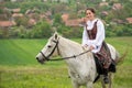 Young woman riding on beautiful horse , having fun in summer time , Romania countryside