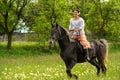 Young woman riding on beautiful horse , having fun in summer time , Romania countryside