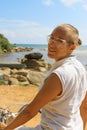 Young woman riding bicycle across river bridge next to tropical park Royalty Free Stock Photo