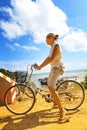 Young woman riding bicycle across river bridge next to tropical park Royalty Free Stock Photo