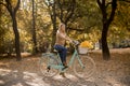 Young woman riding bicycle in golden autumn park Royalty Free Stock Photo