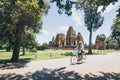 Young woman riding bicycle next to Pre Rup temple in Angkor Wat complex, Cambodia