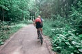 Young woman riding a bicycle in the park in motion, rear view Royalty Free Stock Photo