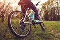 Young woman riding a bicycle in spring forest. Helathy lifestyle concept. Close-up of bike wheel Royalty Free Stock Photo
