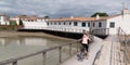 Young woman riding with bicycle on a wooden path to beach in Summer sunny day on island ile de Re in France Royalty Free Stock Photo