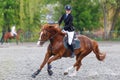 Young woman riding horseback in equestrian showjumping event Royalty Free Stock Photo