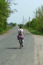 Young woman riding rusty bicycle along the countryside road Royalty Free Stock Photo