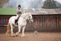 Young woman riding shire horse