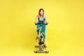 Young woman riding on spinning bike, cycling on gym machine bicycle, motivation, sporty goal concept Royalty Free Stock Photo