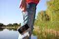 Young woman in ripped jeans standing on the beach with old film camera in the hand