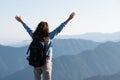 Young woman rising hands against high mountains on background Royalty Free Stock Photo