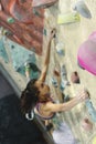 Young Woman Rock climber is Climbing At Inside climbing Gym. slim pretty Woman Exercising At Indoor Climbing Gym Wall Royalty Free Stock Photo