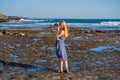 A young woman on a rocky cosmic Bali shore