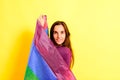 Young woman rolled up in a gay pride flag