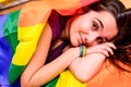 Young woman rolled up in a gay pride flag