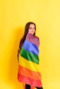 Young woman rolled up in a gay pride flag