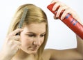 Young woman with roller comb and hairspray Royalty Free Stock Photo