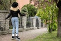 Young woman roller skating on spring day, back view Royalty Free Stock Photo
