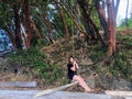 A young woman on a rope swing attached to a tree branch