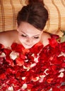 Young woman in rose petal swim water.