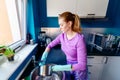 Young woman in rubber gloves washing dishes Royalty Free Stock Photo