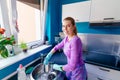 Young woman in rubber gloves washing dishes Royalty Free Stock Photo