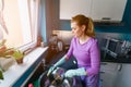 Young woman in rubber gloves washing dishes Royalty Free Stock Photo