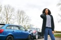 Female Driver With Whiplash Injury Standing By Damaged Car After Road Traffic Accident