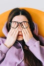 Young woman rubs her eyes after using glasses in front laptop. Eye pain or fatigue concept Royalty Free Stock Photo