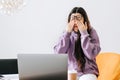 Young woman rubs her eyes after using glasses in front laptop. Eye pain or fatigue concept Royalty Free Stock Photo