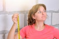 A young woman with a ruler in her hands in a built house. Measurement in the construction and repair of a new home. The girl with Royalty Free Stock Photo