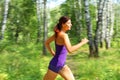 Young woman runner in a green forest