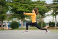 Young woman runner stretching legs before run in park Royalty Free Stock Photo