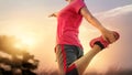 Young woman runner stretching legs before running in sunset rural