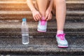 Young woman runner tying shoelaces. Exercise concept