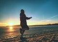 Woman running along shore of a frozen lake in winter spring Royalty Free Stock Photo