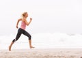 Young Woman Running Along Winter Beach Royalty Free Stock Photo