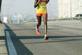 Young woman running on city bridge road. Marathon running in the morning light . Running on city road. Athlete runner feet running