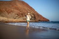 Young woman running on La Tejita beach, Tenerife , Spain Royalty Free Stock Photo