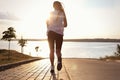 Young woman running near river in morning, back view Royalty Free Stock Photo