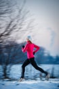Young woman running outdoors on a cold winter day Royalty Free Stock Photo