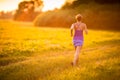 Young woman running outdoors on a lovely sunny summer evening Royalty Free Stock Photo