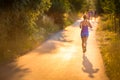 Young woman running outdoors on a lovely sunny summer evening Royalty Free Stock Photo