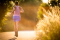 Young woman running outdoors on a lovely sunny summer evening Royalty Free Stock Photo